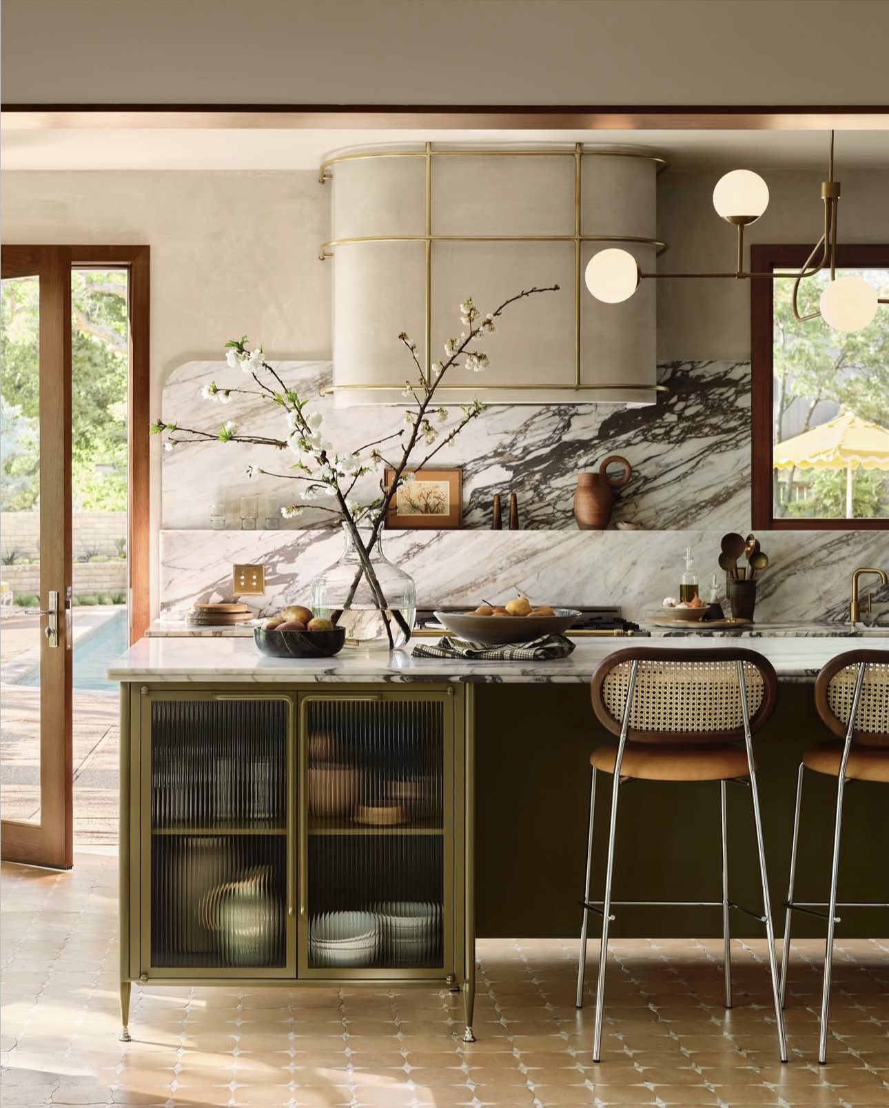 Cozy Marble Kitchen Featuring a Sleek Arched Vent Hood