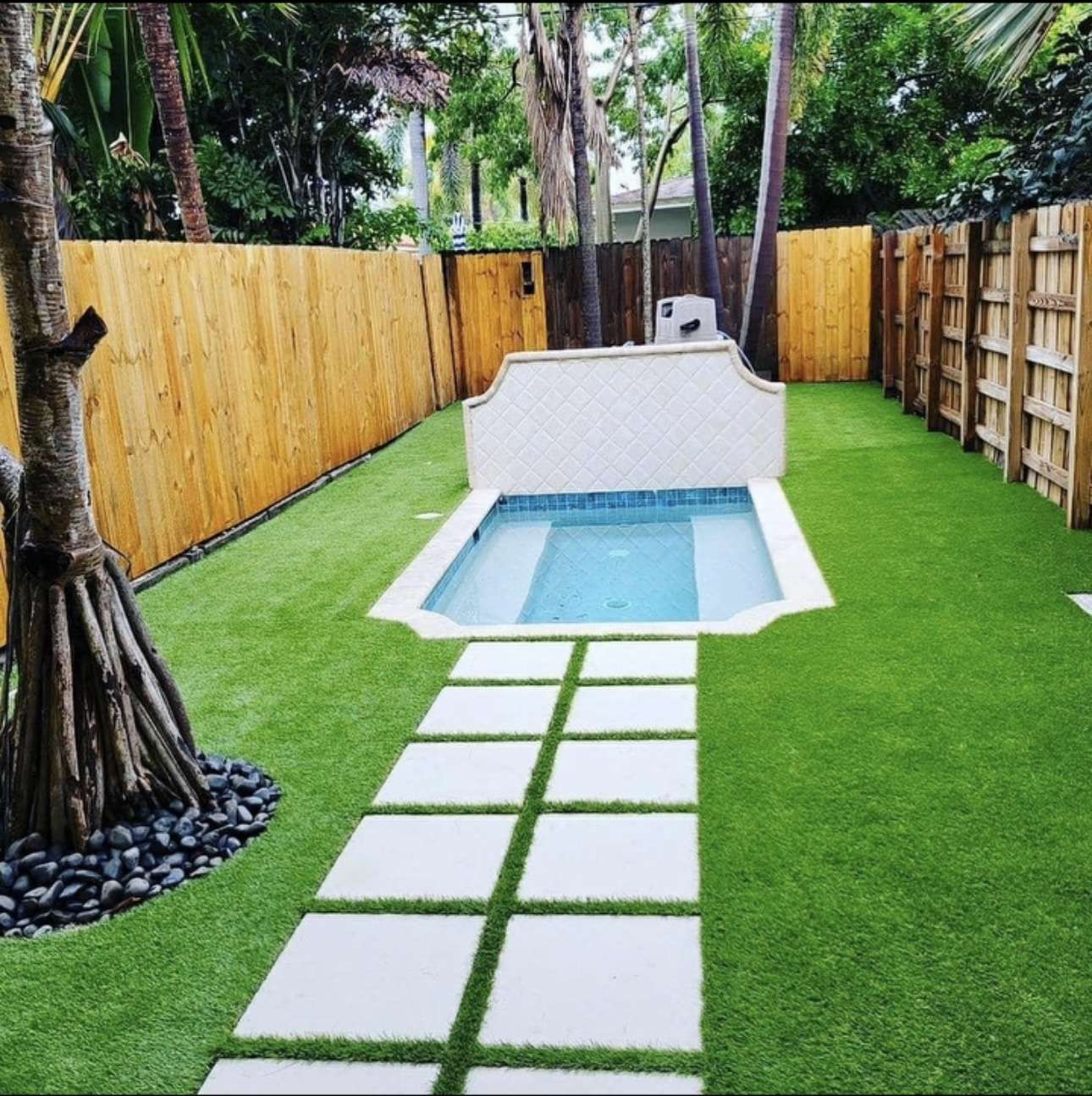 Compact Pool Featuring Faux Grass and Stone Pathway