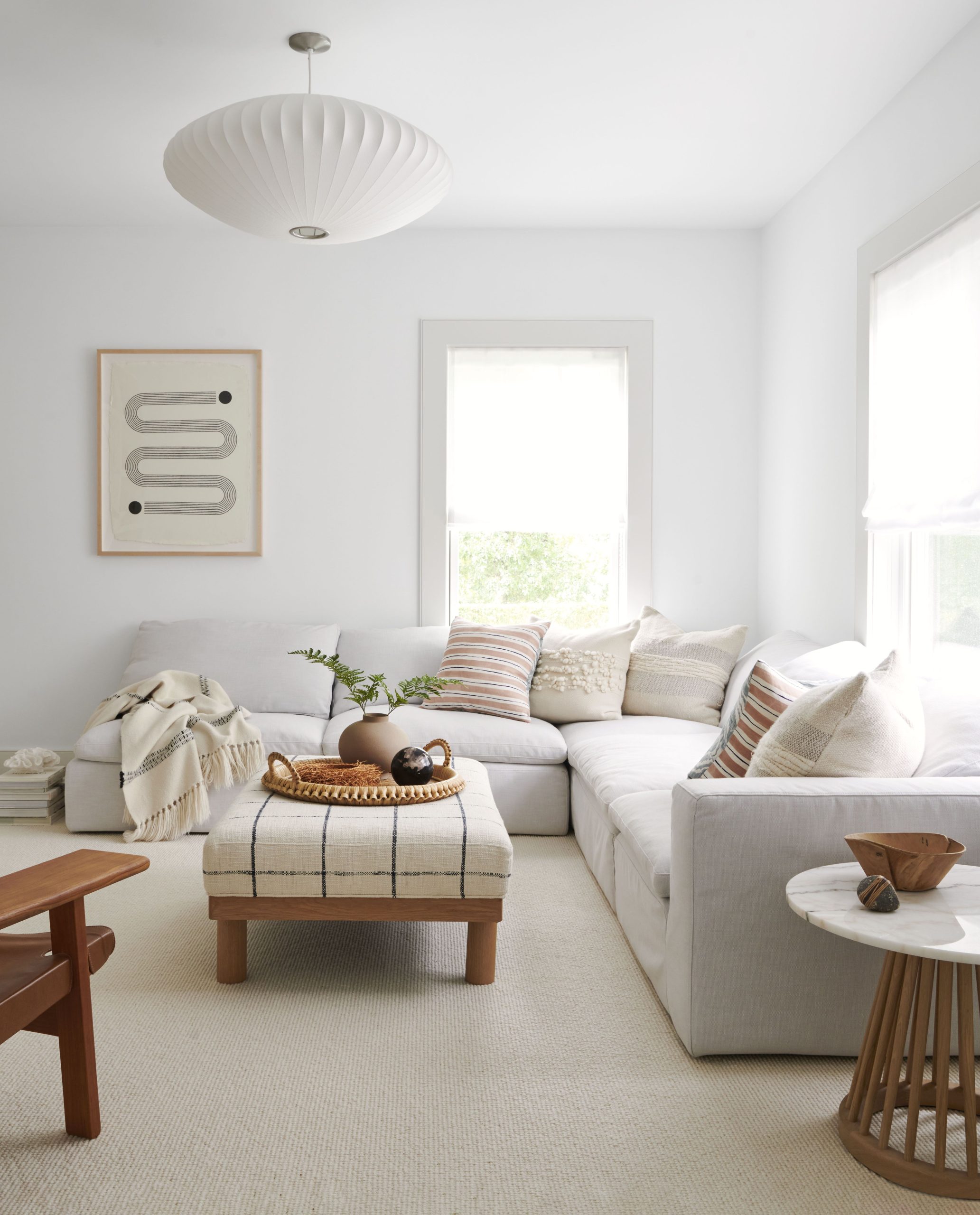 Sleek White Sectional Paired with Plaid Ottoman and Luxe Marble Touches