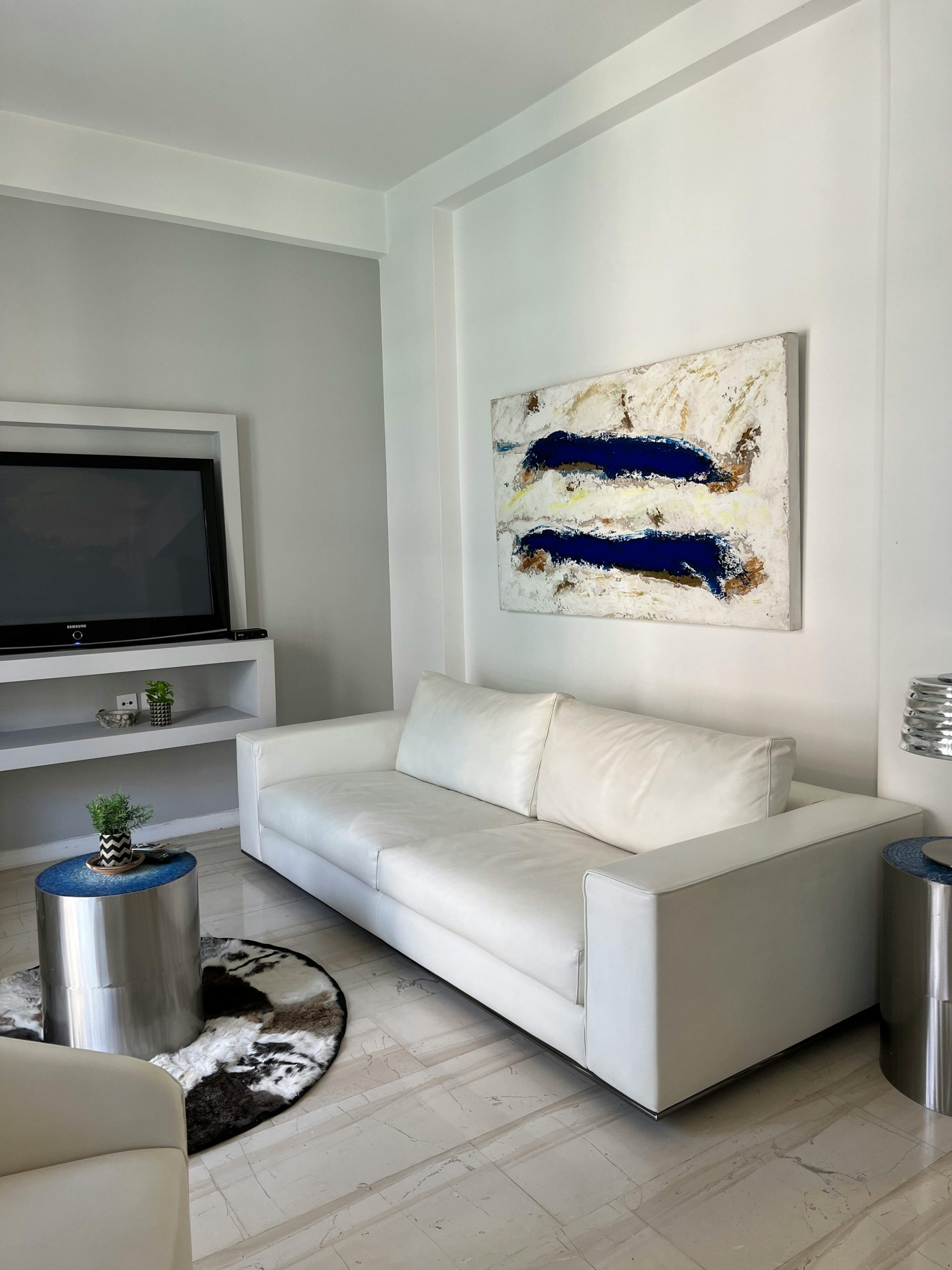 Sleek Serenity: White Sofa Meets Bold Blue Abstract