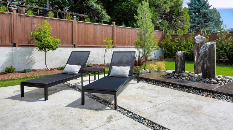 Sleek Concrete Patio Framed by Pebble Accents