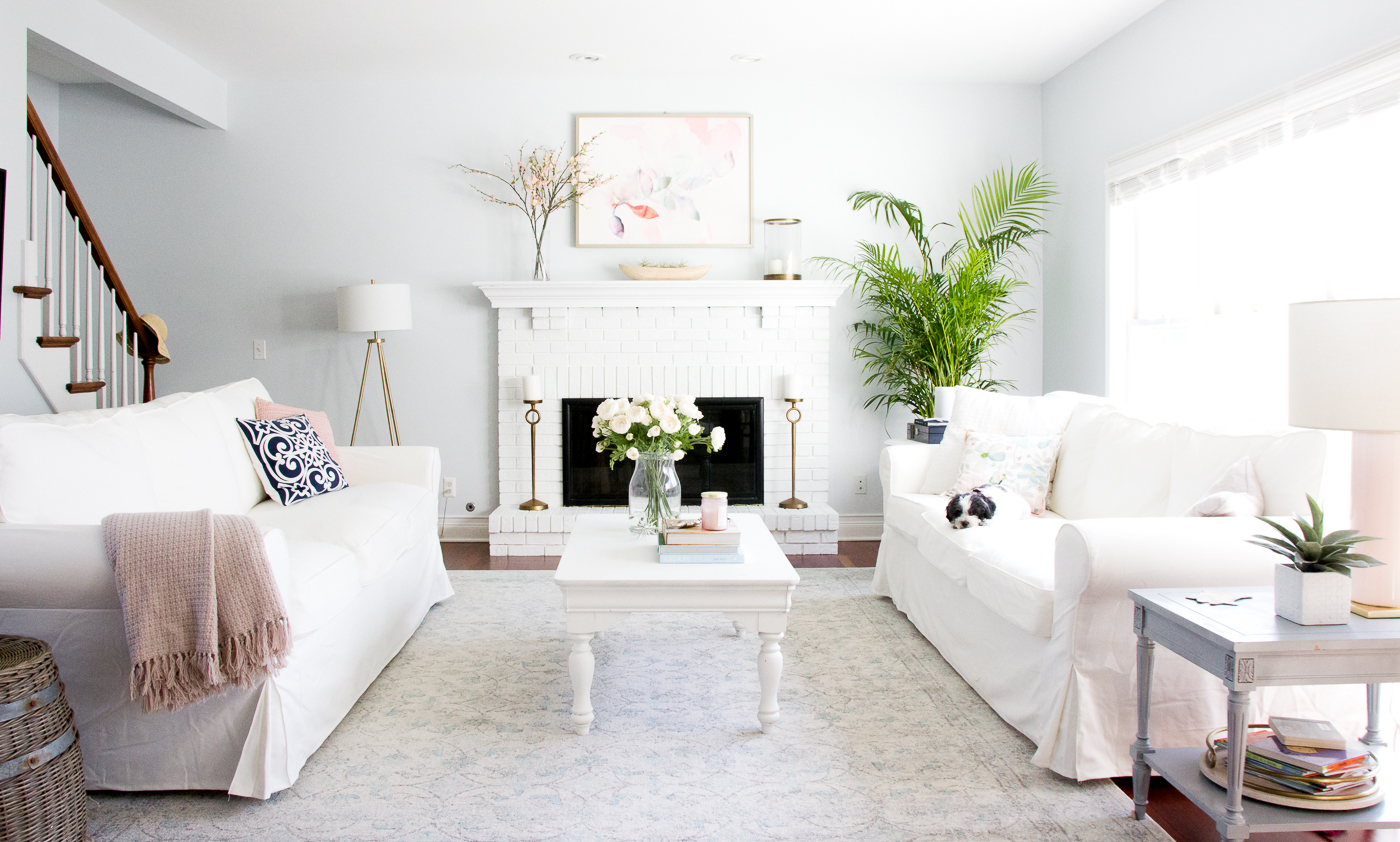 Tranquil White Slipcovered Sofas Framed by Blue Walls and a Rustic Brick Hearth