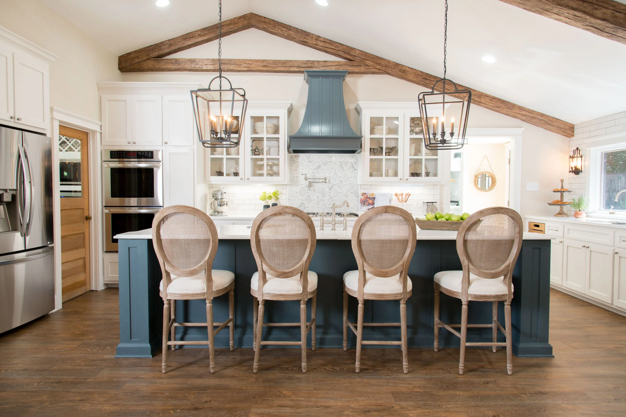 Rustic Culinary Space Featuring Open Ceiling Beams and a Vibrant Blue Stove Hood